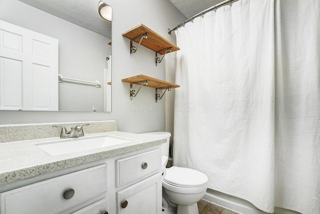 bathroom with toilet, vanity, and a textured ceiling