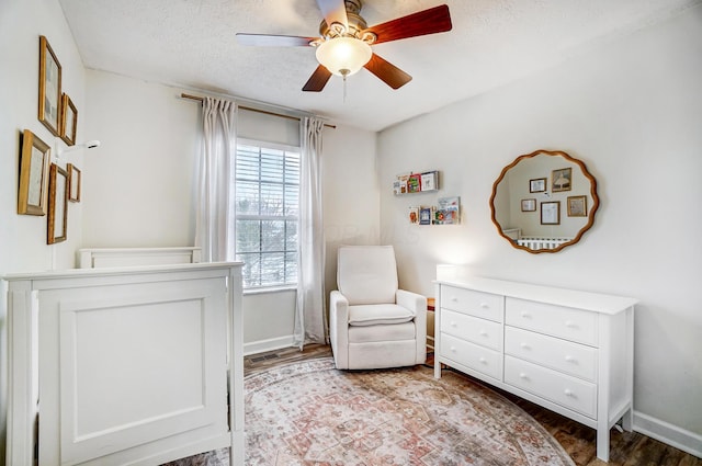 living area featuring hardwood / wood-style flooring, a textured ceiling, and ceiling fan