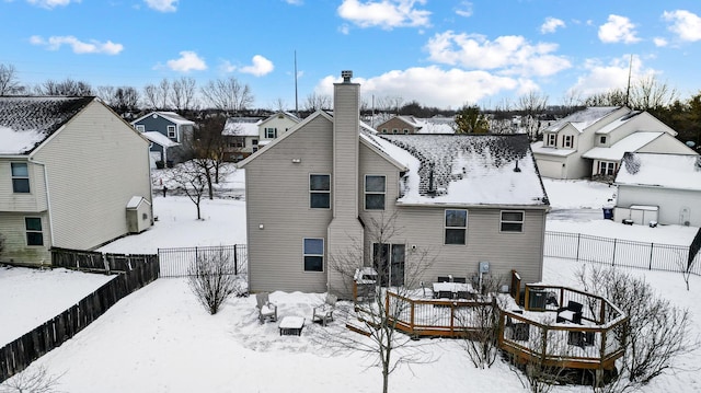 snow covered house featuring a wooden deck