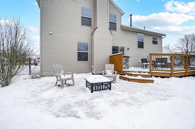 snow covered rear of property featuring a deck