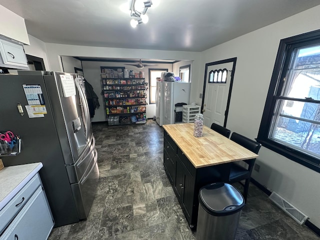 kitchen featuring butcher block countertops and stainless steel fridge with ice dispenser