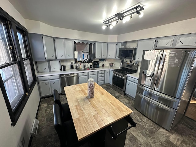 kitchen featuring stainless steel appliances, sink, and gray cabinets