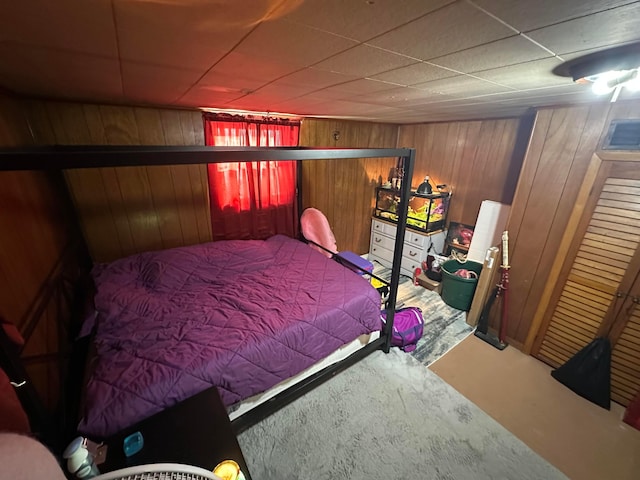 bedroom featuring wooden walls and carpet floors