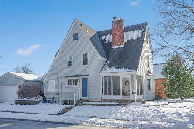 snow covered house with a garage