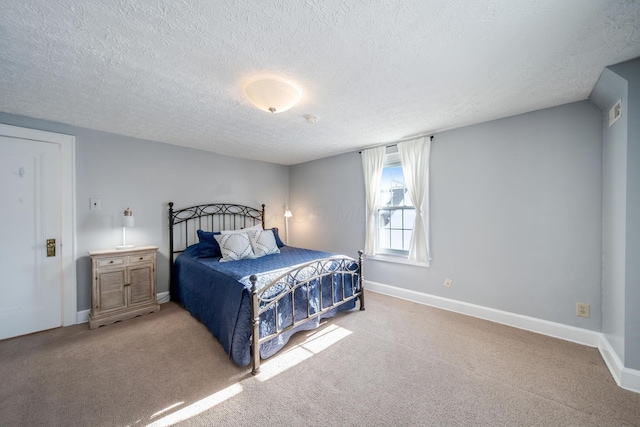 bedroom with a textured ceiling and light colored carpet