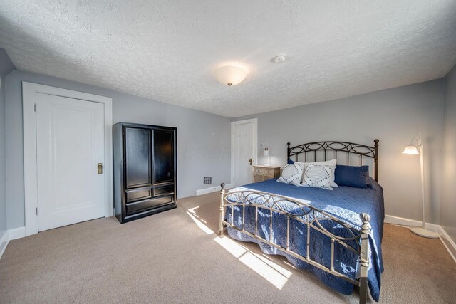 bedroom with a textured ceiling and carpet floors