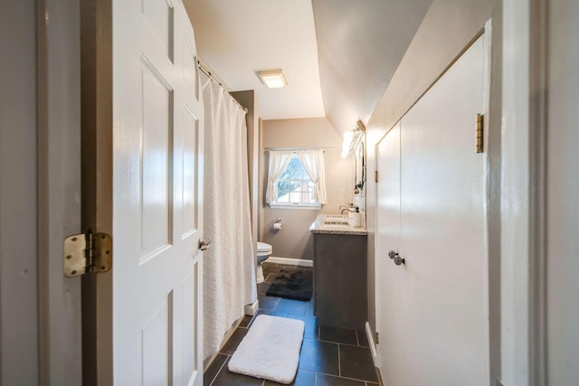 bathroom with lofted ceiling, toilet, tile patterned floors, and vanity