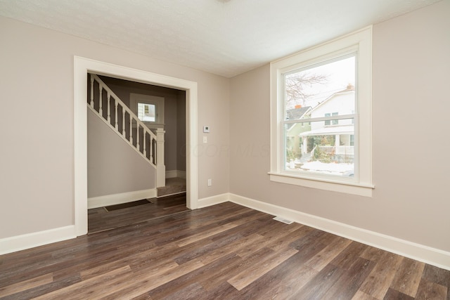 empty room featuring a textured ceiling and dark hardwood / wood-style flooring