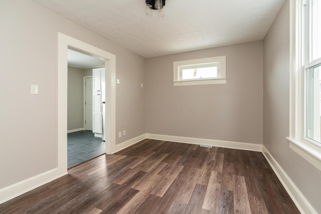 empty room featuring dark hardwood / wood-style flooring and a textured ceiling