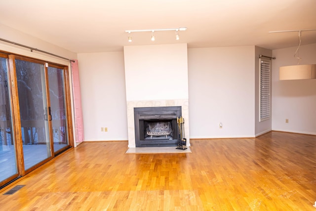 unfurnished living room featuring a fireplace and light hardwood / wood-style floors