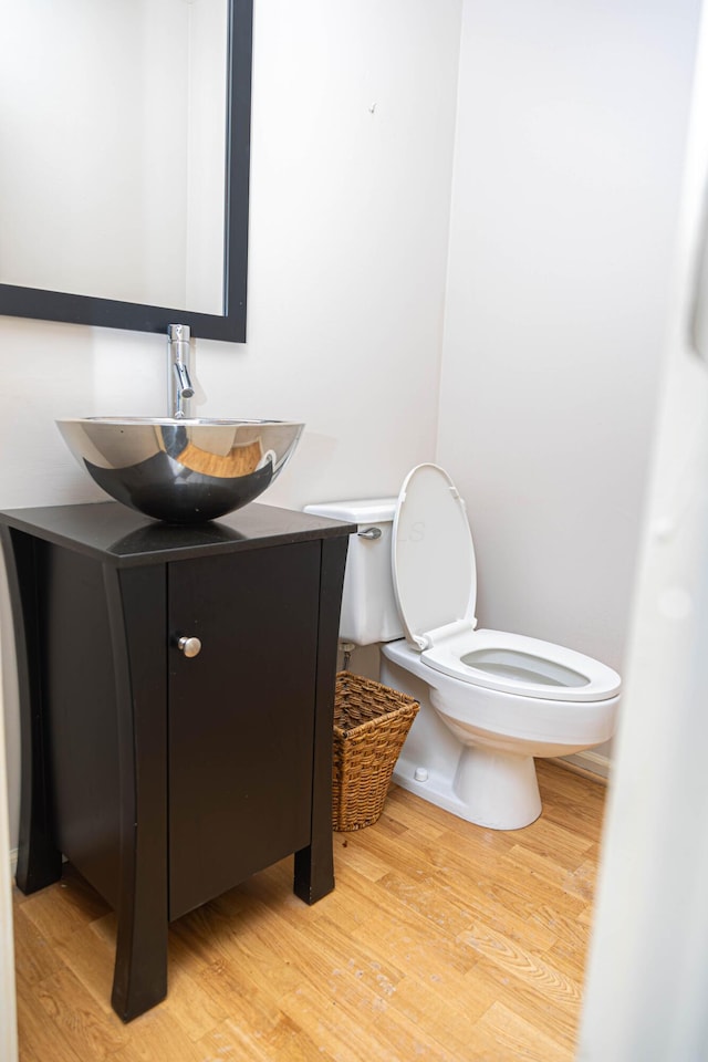 bathroom with hardwood / wood-style floors, toilet, and vanity