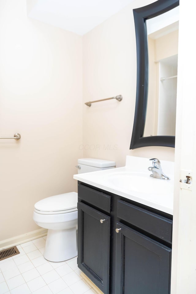 bathroom with tile patterned flooring, vanity, and toilet