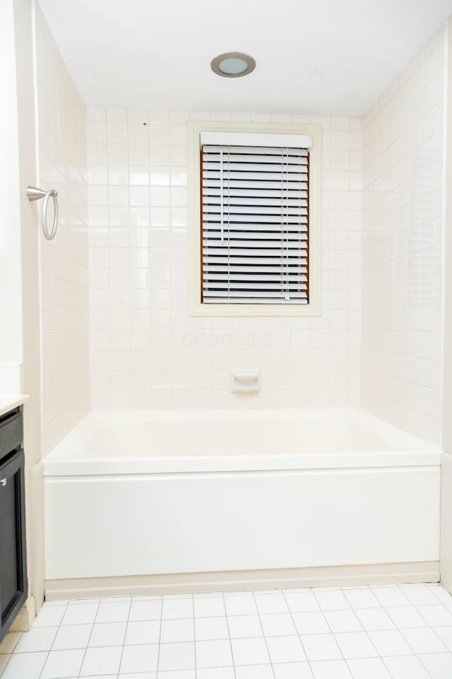 bathroom with vanity, tile patterned flooring, and tiled shower / bath