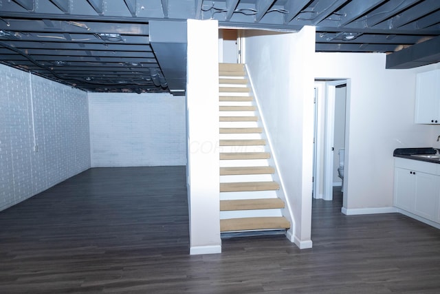 basement featuring sink and dark wood-type flooring