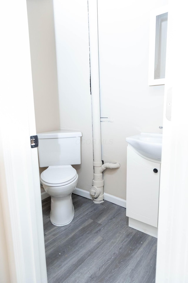 bathroom with hardwood / wood-style floors, vanity, and toilet