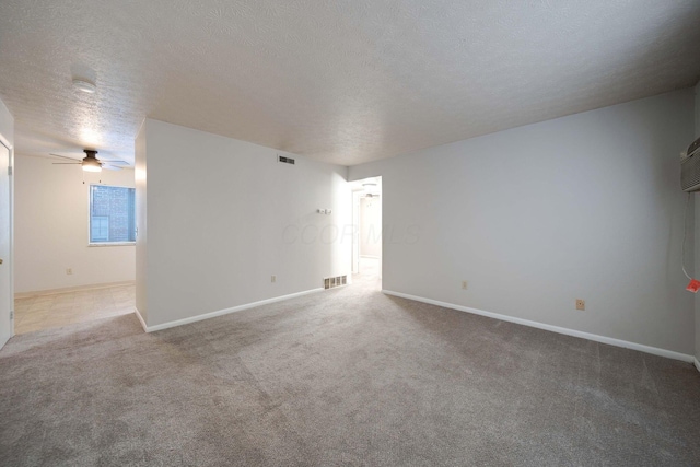 carpeted empty room featuring ceiling fan and a textured ceiling