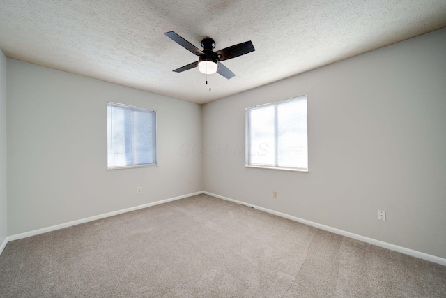 carpeted spare room featuring ceiling fan and a textured ceiling