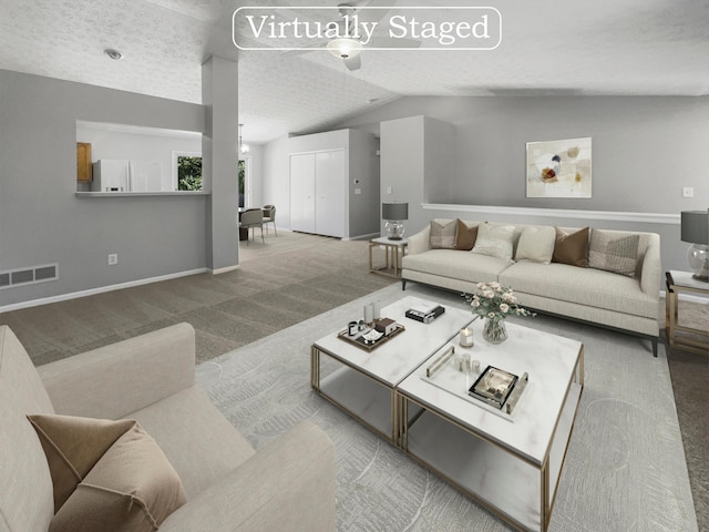 carpeted living room with lofted ceiling and a textured ceiling