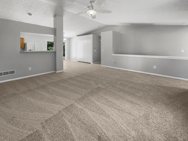 unfurnished living room featuring a textured ceiling, light colored carpet, vaulted ceiling, and ceiling fan