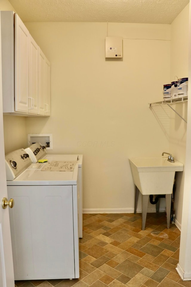 laundry area featuring cabinets, a textured ceiling, and independent washer and dryer