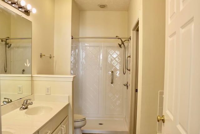 bathroom featuring vanity, toilet, walk in shower, and a textured ceiling