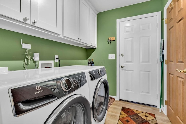 laundry area with cabinets, light hardwood / wood-style floors, and independent washer and dryer