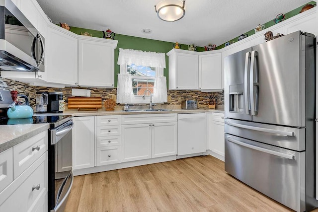 kitchen with sink, white cabinets, and appliances with stainless steel finishes