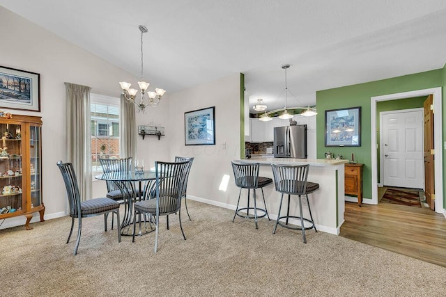 carpeted dining space with lofted ceiling and an inviting chandelier