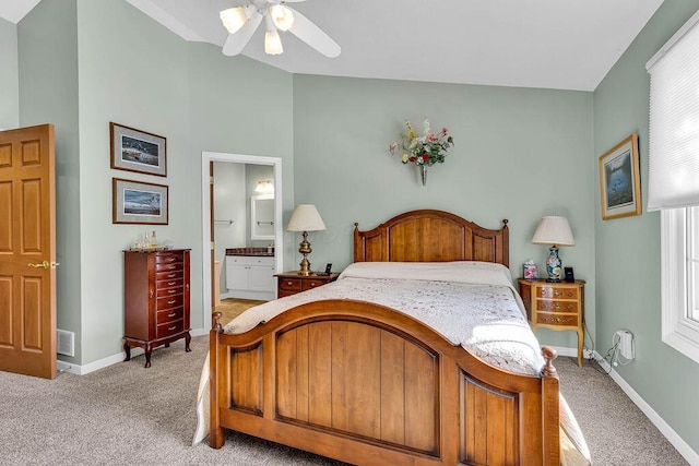 bedroom featuring ceiling fan, light colored carpet, and ensuite bath