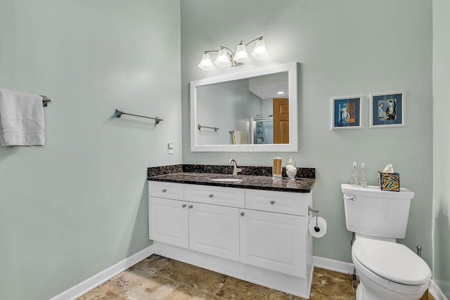 bathroom with toilet, vanity, and an enclosed shower