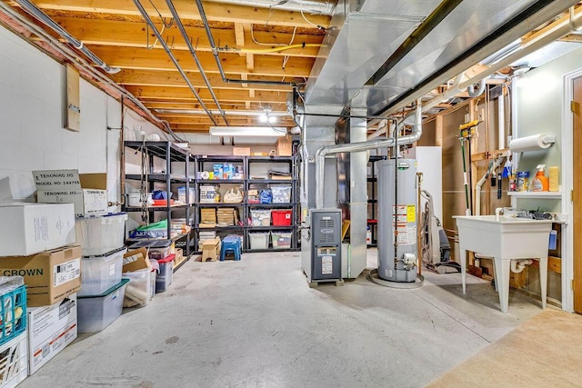 basement with heating unit, water heater, and sink