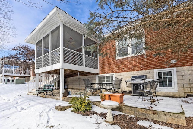 snow covered property with a sunroom