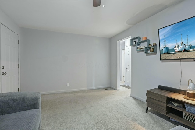 sitting room with ceiling fan and light colored carpet