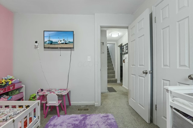 bedroom featuring light colored carpet and a crib