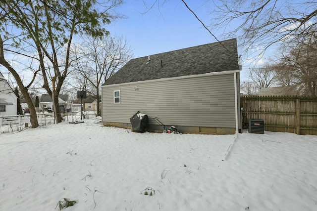 snow covered property with central air condition unit