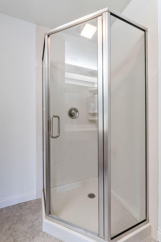 bathroom with an enclosed shower and a textured ceiling