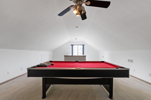 rec room featuring ceiling fan, vaulted ceiling, light colored carpet, and a textured ceiling