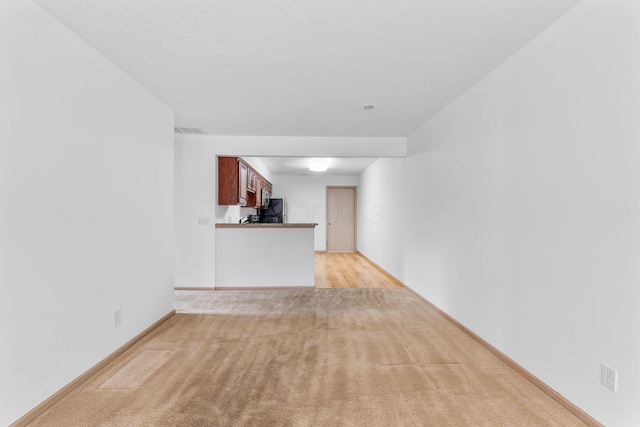 unfurnished living room featuring light carpet