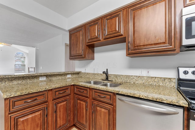 kitchen with sink, light stone countertops, and appliances with stainless steel finishes