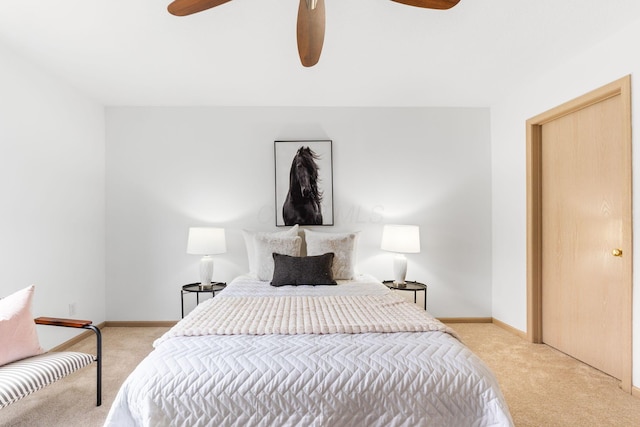 bedroom featuring light carpet, a ceiling fan, and baseboards