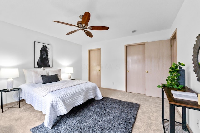 bedroom with a ceiling fan, light carpet, and baseboards