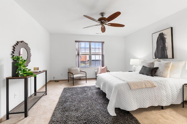 bedroom featuring light colored carpet, ceiling fan, and baseboards