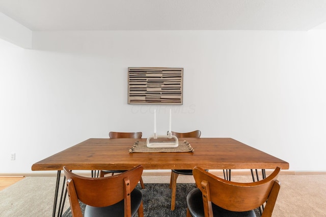 dining area featuring carpet and baseboards