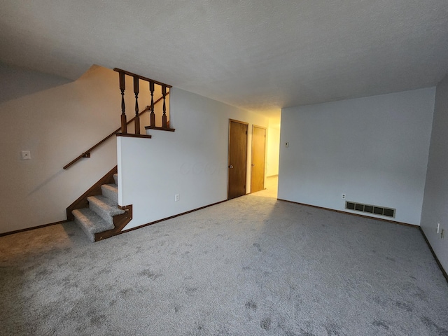 unfurnished living room with carpet and a textured ceiling