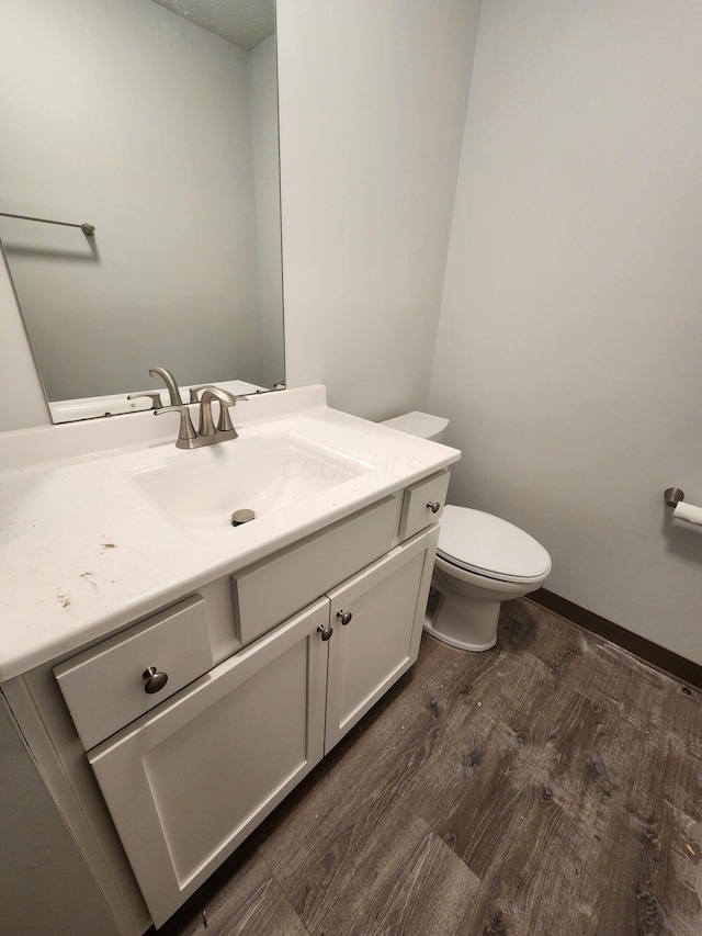 bathroom featuring hardwood / wood-style flooring, toilet, and vanity