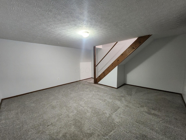 bonus room featuring carpet floors and a textured ceiling