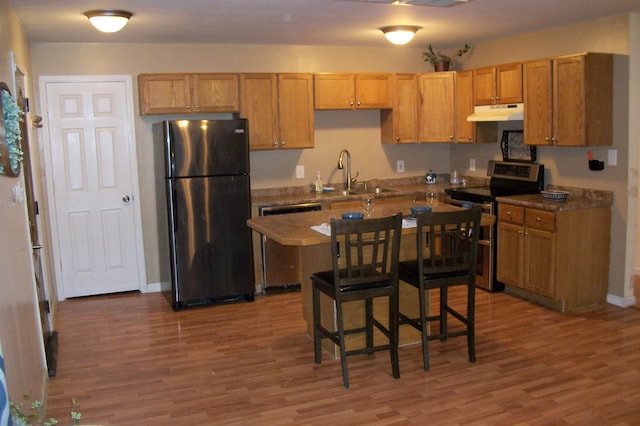 kitchen with appliances with stainless steel finishes, dark hardwood / wood-style floors, and sink