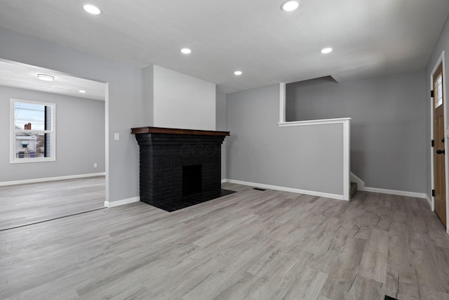 unfurnished living room with light hardwood / wood-style flooring and a fireplace