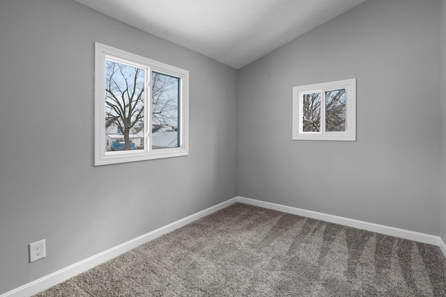 carpeted empty room with vaulted ceiling