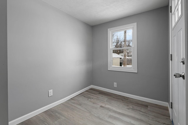 unfurnished room featuring light hardwood / wood-style floors and a textured ceiling